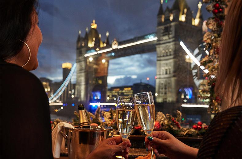 Woman clinking glasses at Vicinity restaurant in Tower Hotel London