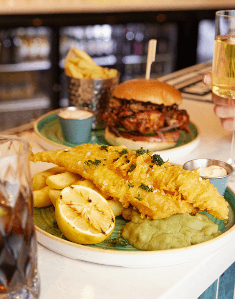 Photo of a plate of fish and chips with a glass of coke on the side