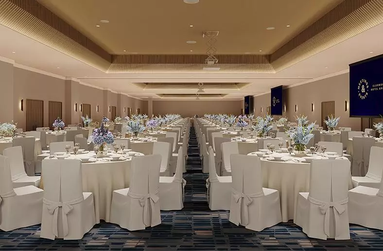 The Tower suite at The Tower Hotel London decorated for a banquet with rows of round tables decorated with white cloths and blue flowers in the middle of each table