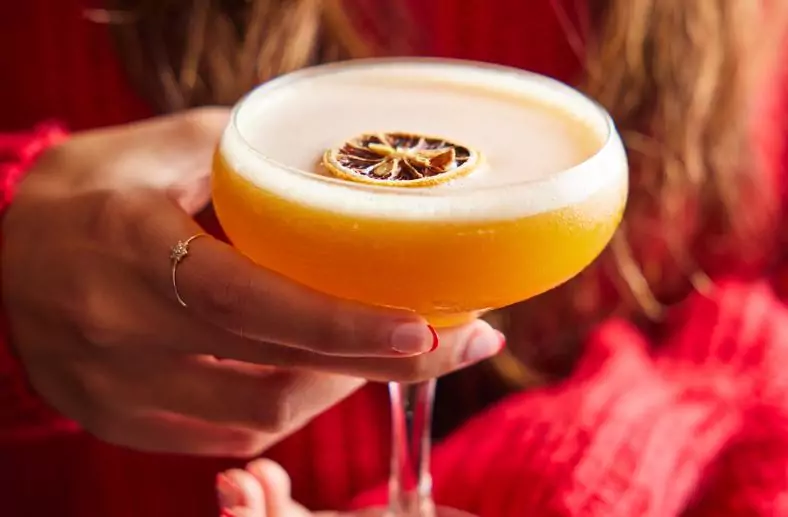 Girl holding passion fruit martini cocktail