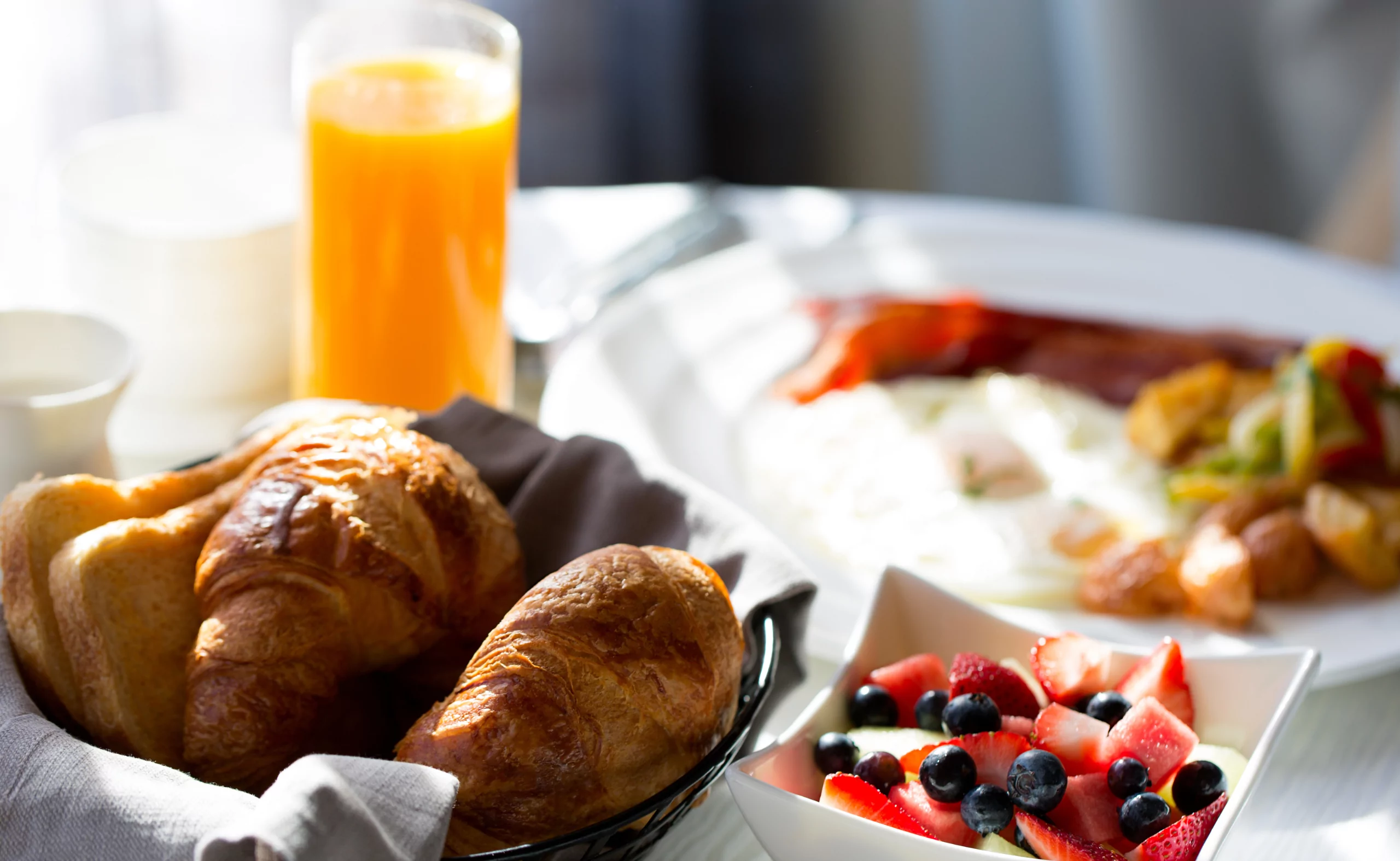 Breakfast with croissants, fruit, juice on a white tablecloth